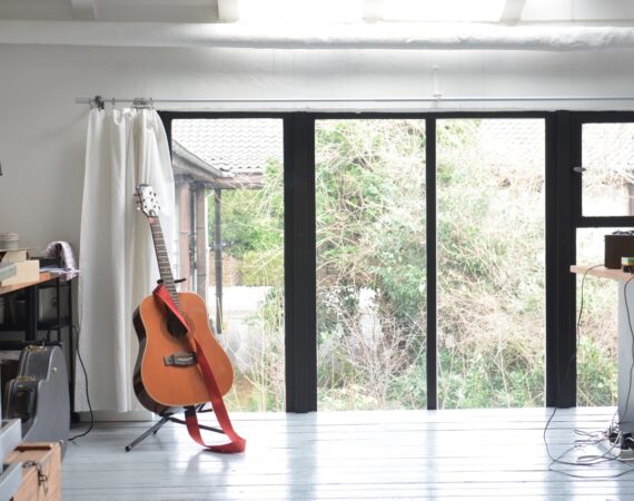 Stue med guitar og stort vindue